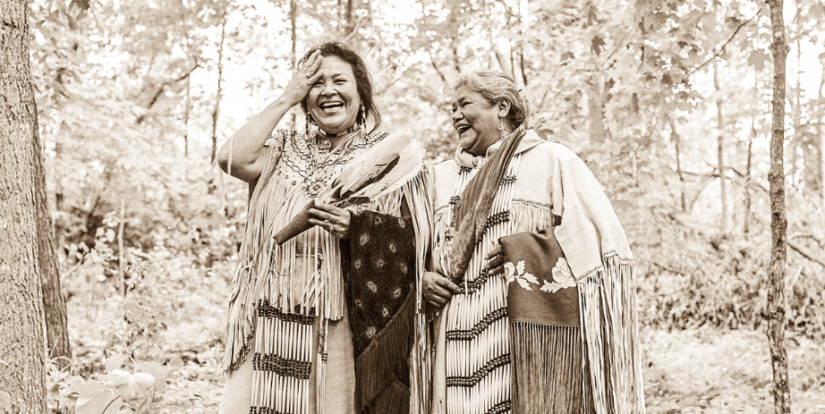 Sepia-toned image of two Indigenous women walking in woods