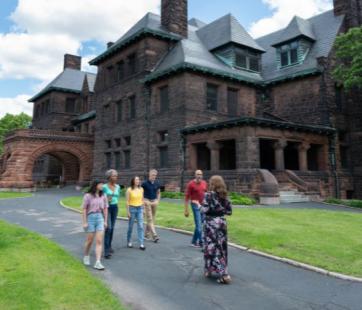 A guide leads a tour group outside Hill House